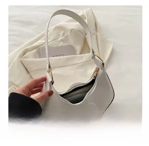 Capacité intérieure détaillée montrant les articles dans le sac hobo blanc