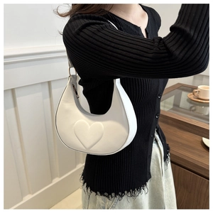 Détail d'un sac hobo blanc avec motif de cœur en relief et bandoulière élégante