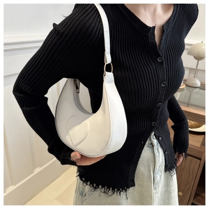 Gros plan d'un sac hobo blanc avec motif cœur en relief et boucles dorées à l'épaule