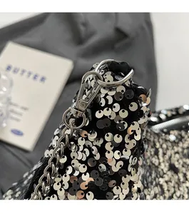 Detail of shimmering silver sequins on a fashion chain bag with premium metal hardware
