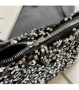Detail view of smooth silver zipper and glossy black sequins on this stylish handbag