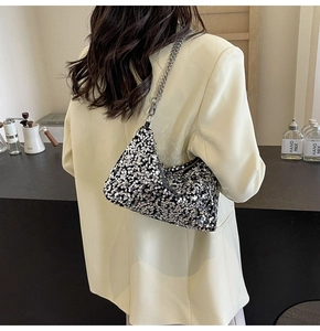 Detail of shimmering silver sequins and silver chain strap on a stylish shoulder bag