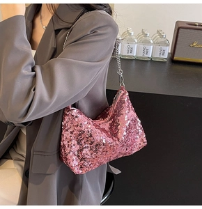 Detailed view of pink sequin shoulder bag with silver chain strap on a model