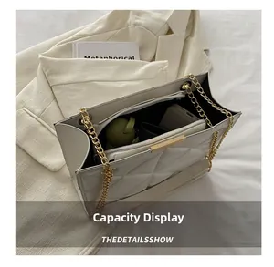 Spacious interior of beige quilted tote bag with gold chain and daily essentials