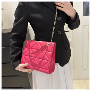 Macro shot of hot pink quilted tote bag with gold chain strap and luxury texture