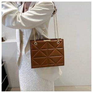 Detail of a brown leather tote with geometric quilting and a golden chain strap