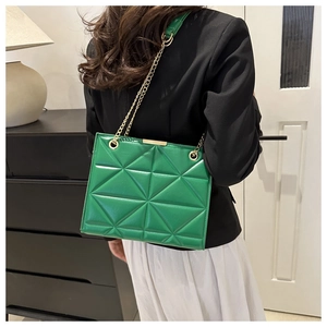 Detail view of emerald green leather crossbody bag featuring geometric quilted patterns