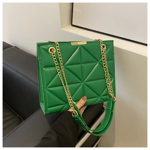 Close-up of green tote bag with triangular embossed pattern and gold chain strap