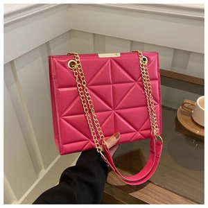 Detail of fuchsia quilted tote bag with triangle stitching and gold metal hardware