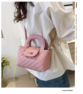 Lifestyle shot showing a pink quilted crossbody bag with golden clasp worn by a model