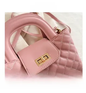 Close-up of pink quilted handbag with premium gold metal twist lock and stitching details