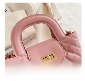 Close-up of pink quilted faux leather handbag with golden metal twist lock and sturdy handle