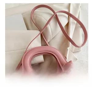 Detail view of pink quilted handbag showing comfortable shoulder strap and handle attachment