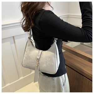 Detail of silver faux leather shoulder bag with vintage texture and gold buckle hook