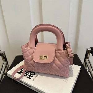 Close-up of pink quilted leather handbag with gold twist lock and sturdy top handle
