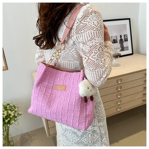 Close-up of pink pleated tote bag with chain strap and white cloud plush charm