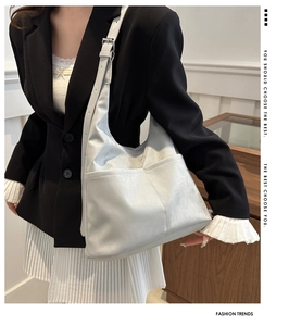 Silver hobo bag with dual front pockets and adjustable strap styled on a model