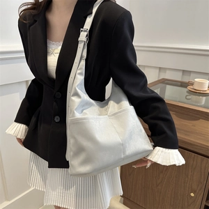Detail view of silver bucket hobo bag with adjustable wide strap and side pockets