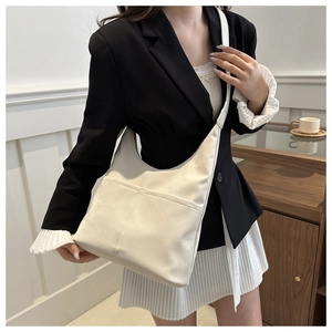 White minimalist tote bag shown on model highlighting spacious capacity and matte texture