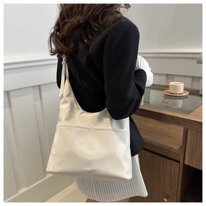 Detail shot of a cream-colored tote bag showing dual pockets and durable nylon texture