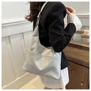 Detail of light gray tote bag with dual front pockets and glossy textured finish