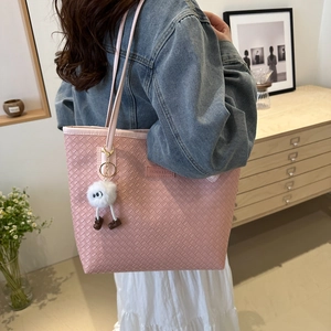 Pink woven tote bag with plush monster charm and Fashion & Bags tag shown on shoulder