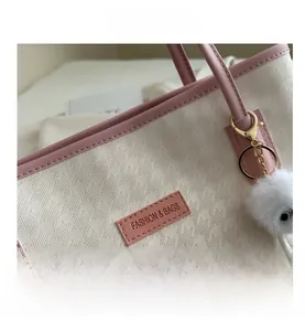 Dettaglio ravvicinato della borsa tote scaccata in ecopelle con finiture rosa e logo