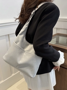 Minimalist light gray leather hobo bucket bag for women shown as a stylish shoulder tote