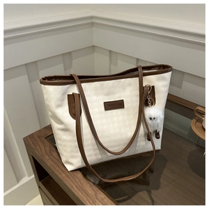 Dettaglio della trama pied de poule della borsa tote con manici in pelle e charm morbido