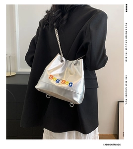 Détail du sac seau argenté avec broderie colorée et bandoulière en chaîne métal