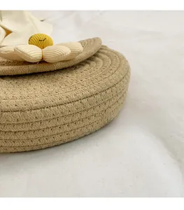 Detailed close-up of woven round saddle bag featuring a handmade 3D daisy flower accent