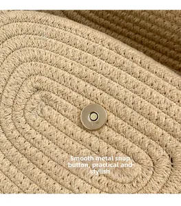 Macro shot of the polished gold magnetic snap on a beige woven straw bag texture