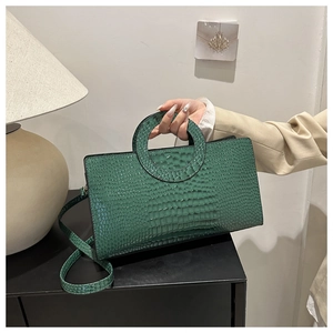 Dettaglio borsa in pelle PU verde scuro con motivo a coccodrillo e grande manico a cerchio