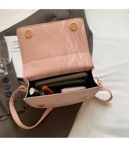 Detail of pink textured crossbody bag showing spacious interior and magnetic closures