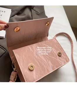 Macro view of pink faux leather bag showing magnetic snap button closure and marble texture