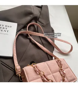 Close-up of pink plaid crossbody bag with acrylic chain and adjustable shoulder strap