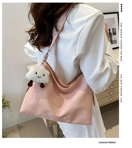 Detail view of pink matte tote bag with fluffy cloud pendant and wide shoulder strap