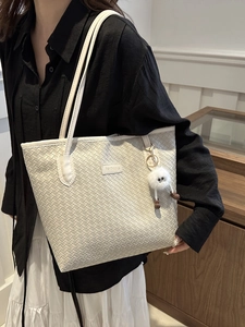 White woven leather tote bag for women with fuzzy monster charm and fashion label