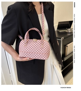 Detailed shot of pink shell bag with vintage pattern on a model in office setting
