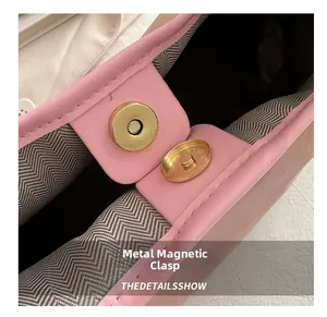 Detail der rosa Ledertasche mit magnetischer Goldschnalle und Fischgrätenfutter