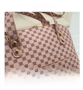 Detail of pink faux leather bag with vintage print and gold metal rivets