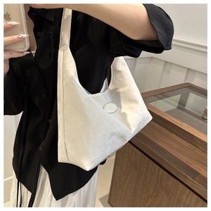 Detailed texture of off-white hobo shoulder bag with round logo and suede finish