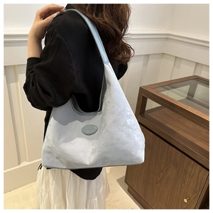 Detailed side view of a large light blue hobo bag showing its soft texture and capacity
