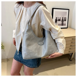 Detail of grey matte Hobo shoulder bag featuring seamless strap and oval logo detail