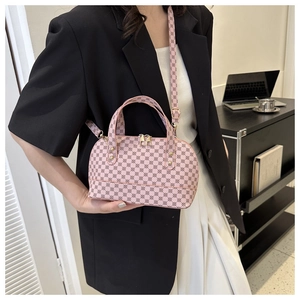 Pink shell bag with geometric prints shown as a crossbody on a stylish model
