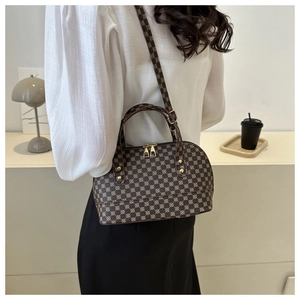 Rear view of a model wearing the dark brown printed shell bag in a minimalist setting