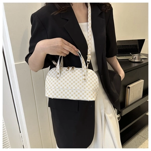 Detail of white vintage shell bag with gold pattern and detachable shoulder strap