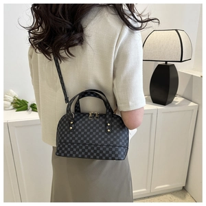 Detail of gray shell bag with chain pattern texture on a minimalist indoor background