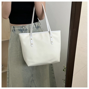 Selfie miroir montrant un grand sac cabas blanc cassé avec des clous dorés chic