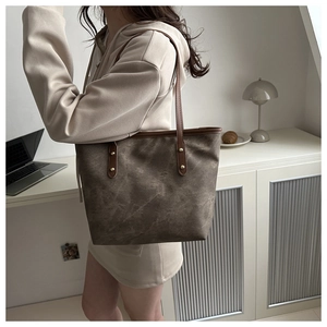 Détail d'un sac cabas à texture marbrée avec des lanières en cuir marron au bureau